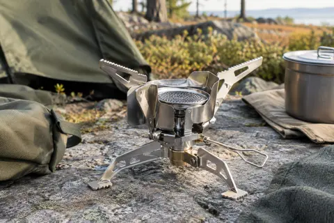 Réchaud de camping pliable argenté avec brûleur, supports déployés et déflecteur coupe-vent intégré