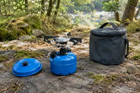 Réchaud de camping bleu en aluminium avec couvercle et sac de transport dans une clairière