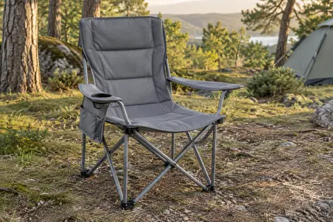 Chaise de camping grise à dossier haut, assise large, poche latérale et porte-gobelet dans une clairière